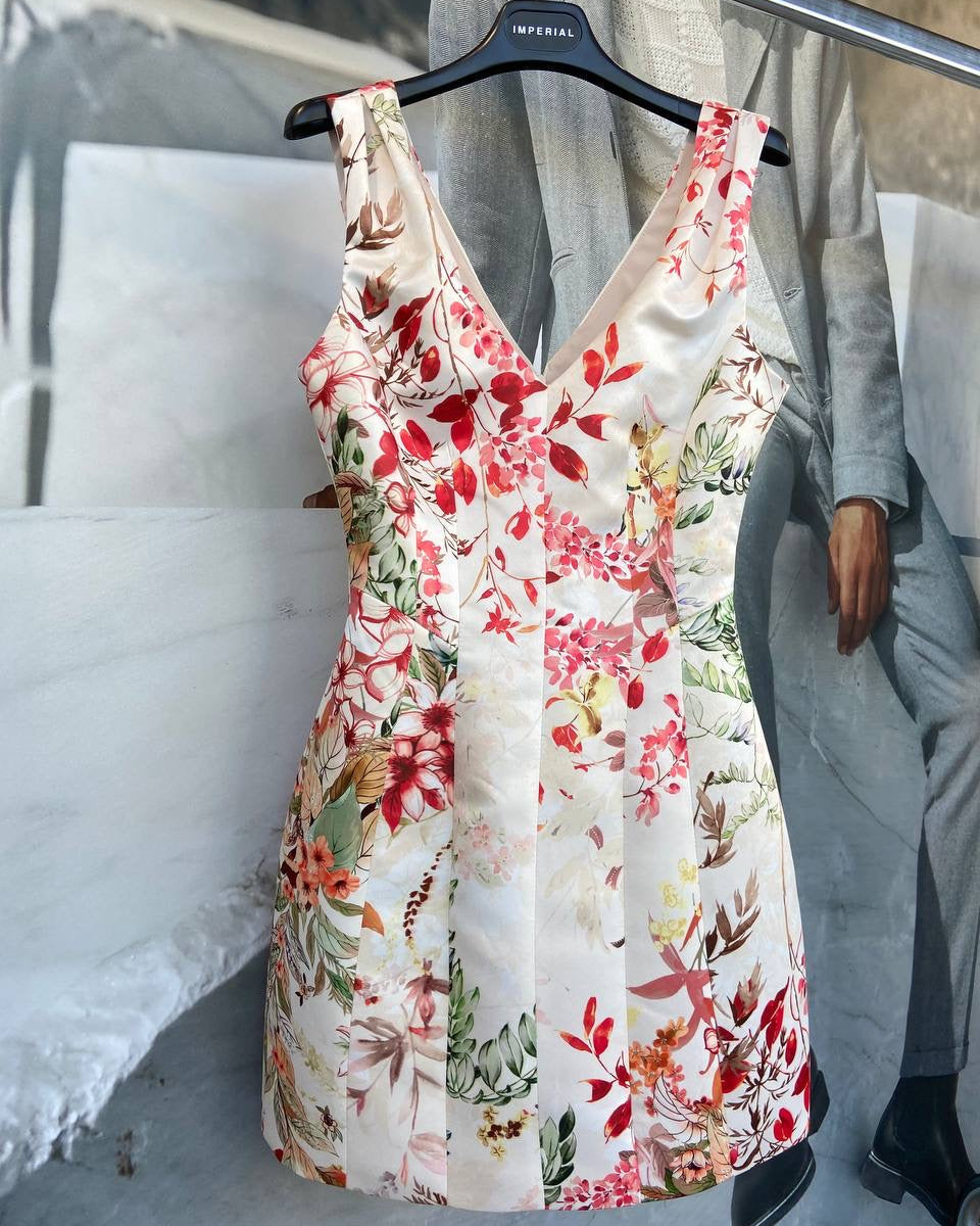 A floral white dress with short sleeves displayed on a hanger.