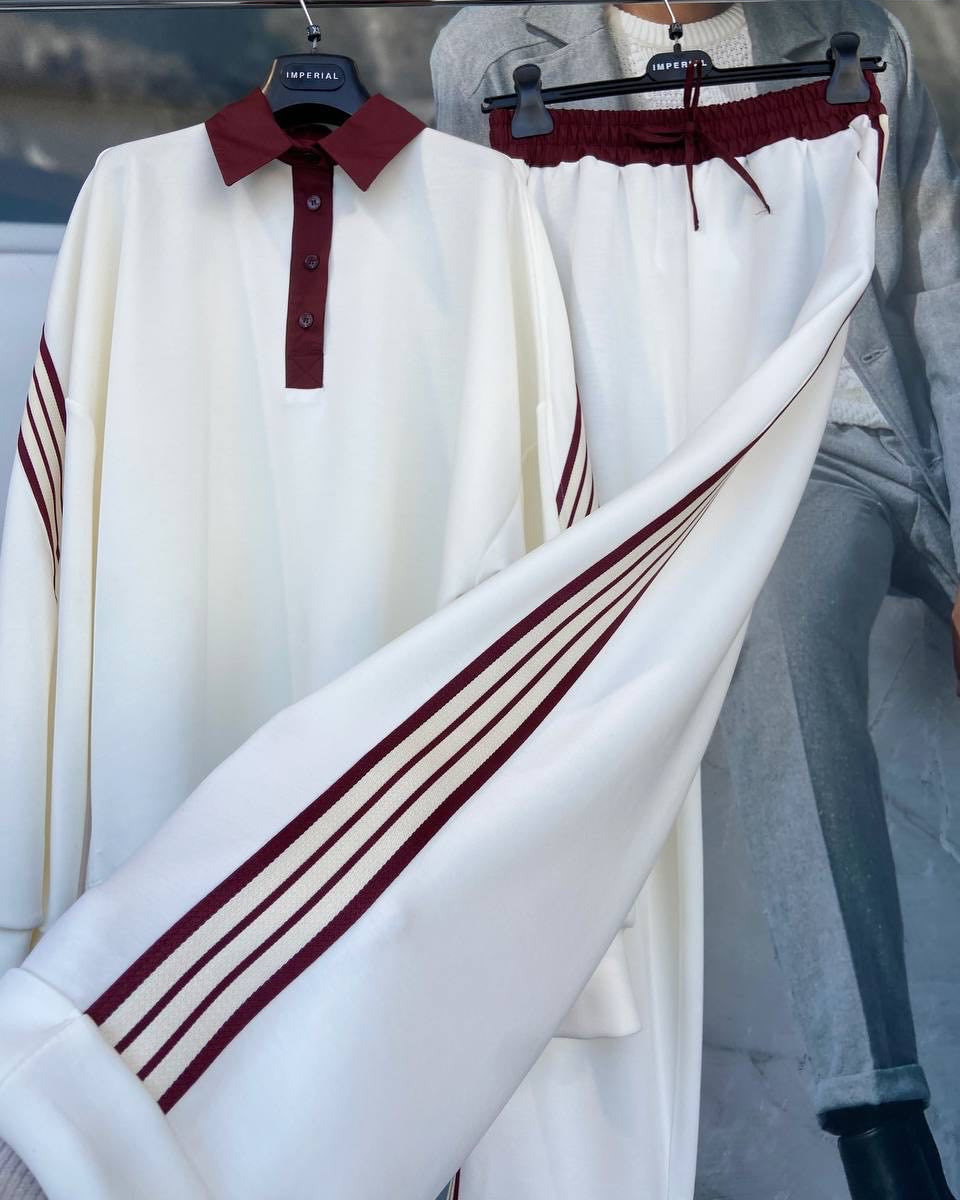 A golf sweater with white body and red stripes on the sleeves, displayed on a mannequin.