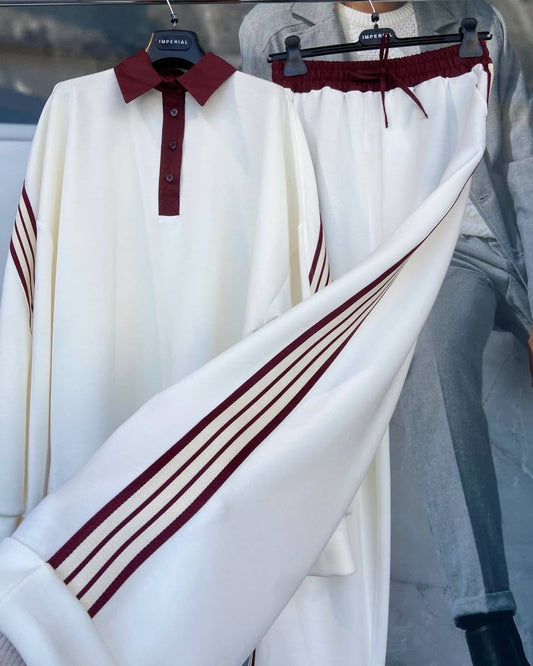 A golf sweater with white body and red stripes on the sleeves, displayed on a mannequin.