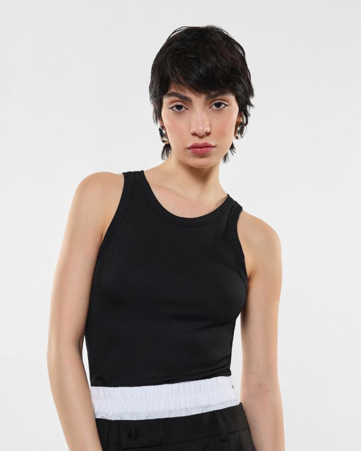 A person wearing a black tank top with a white horizontal stripe at the bottom.