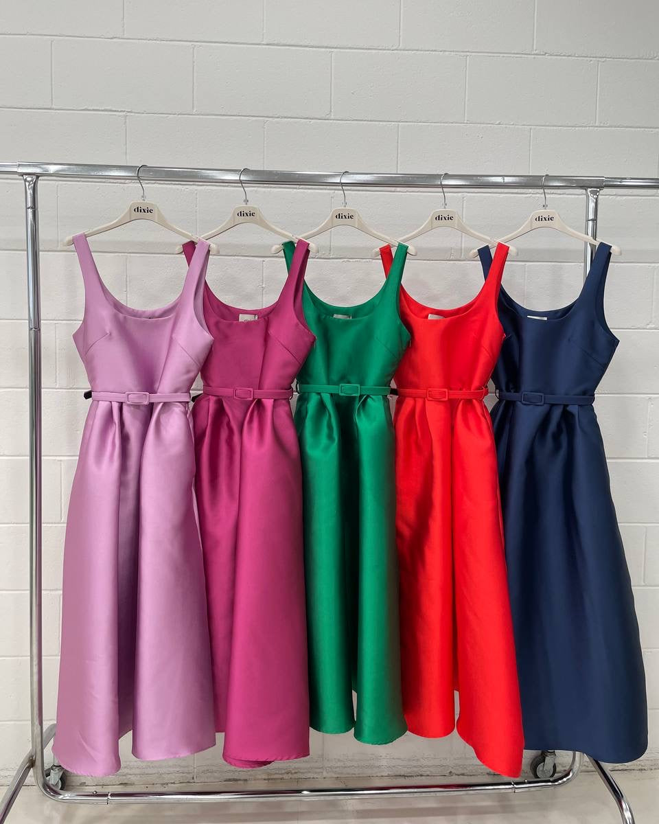 A rack with four sleeveless dresses in pink, green, red, and blue colors, displayed on hangers.