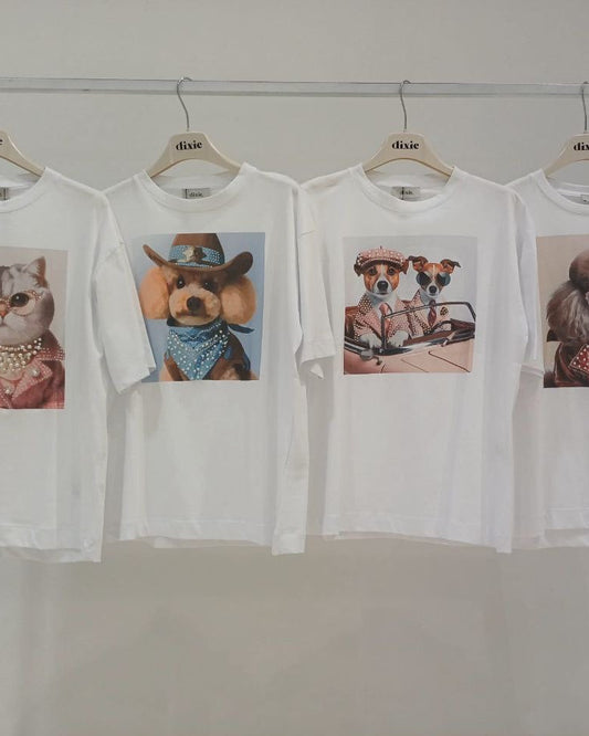 A selection of white t-shirts with different puppy images printed on them, displayed on hangers.