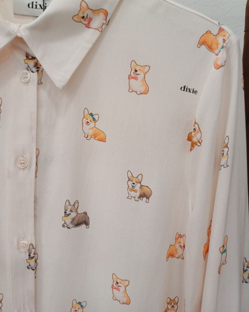 A shirt with a pattern of various dogs, displayed in a vertical column.
