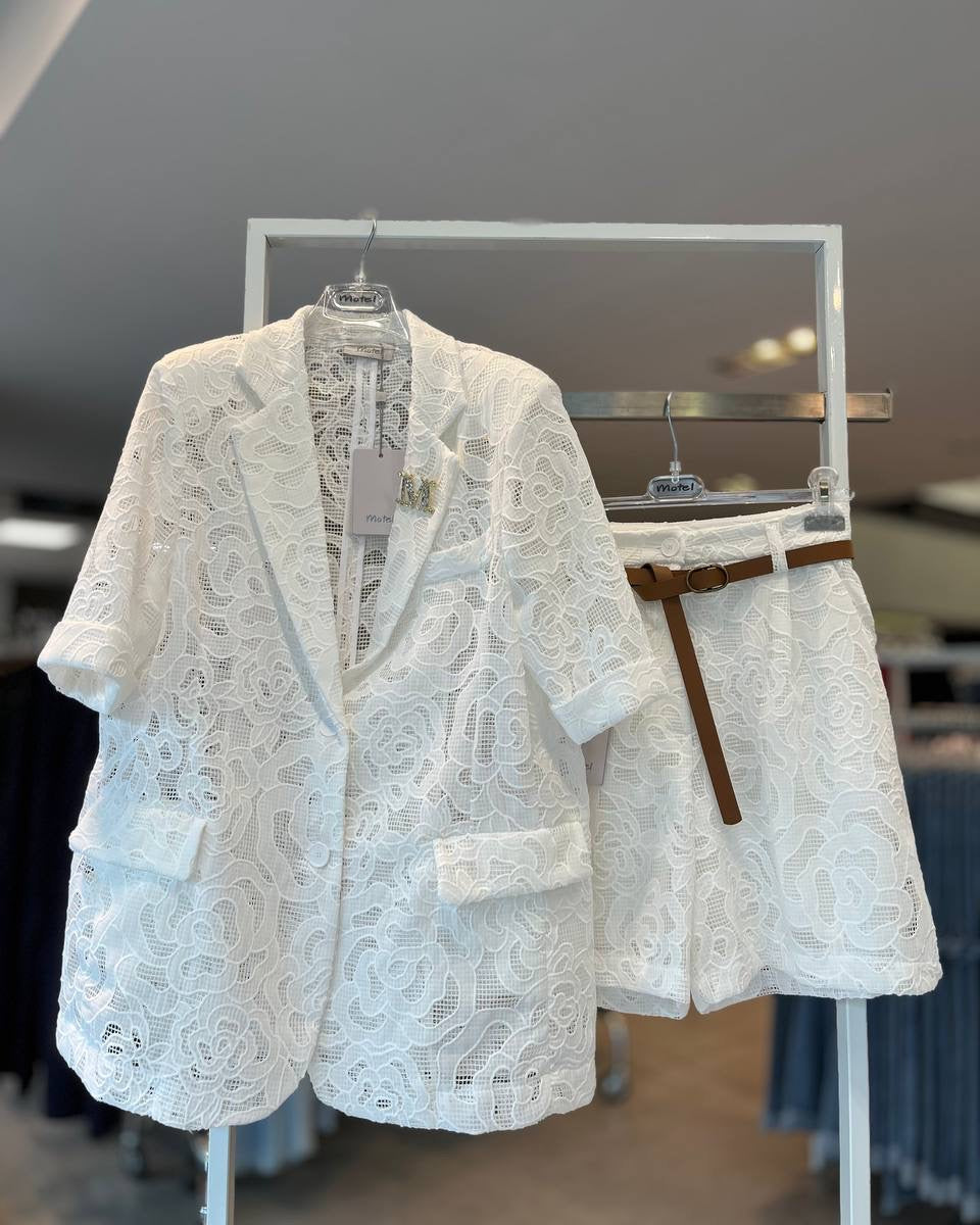 A white lace jacket displayed on a mannequin, featuring short sleeves and a round neckline.