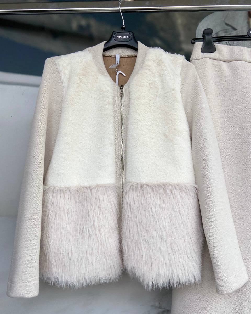 A white sweater with faux fur detailing and a zipper front.