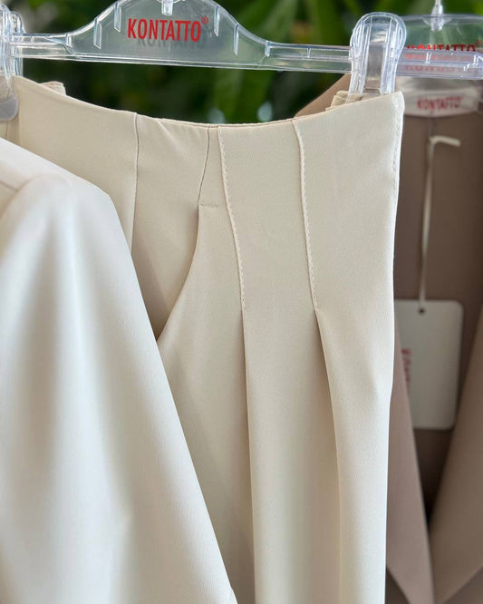Beige pants on a hanger with 'KONTATTO' branding in the background