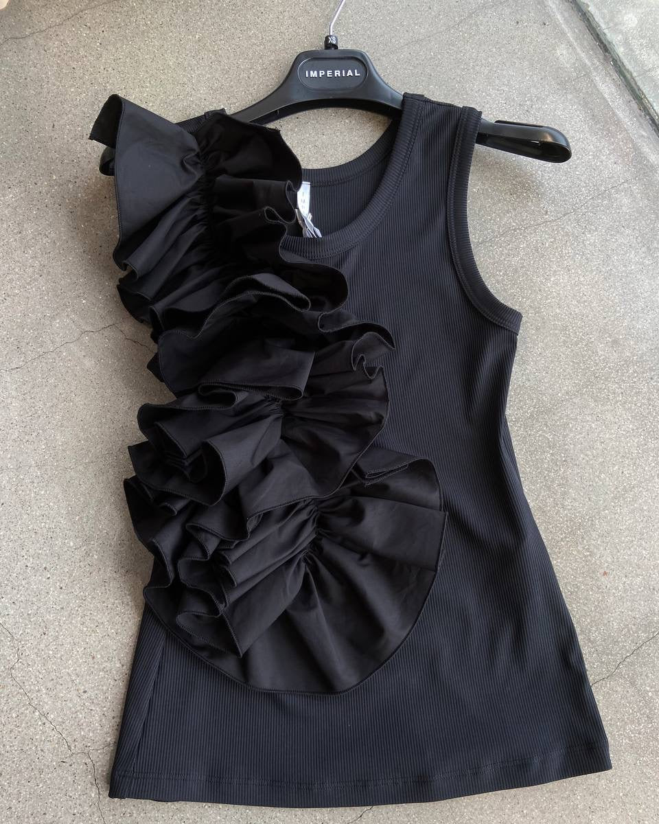 Black sleeveless top with ruffle detail on a hanger against a neutral background