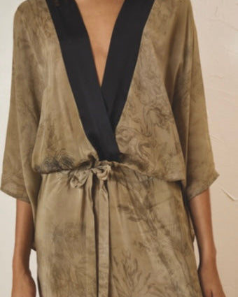Brown patterned garment with black neckline against a plain background