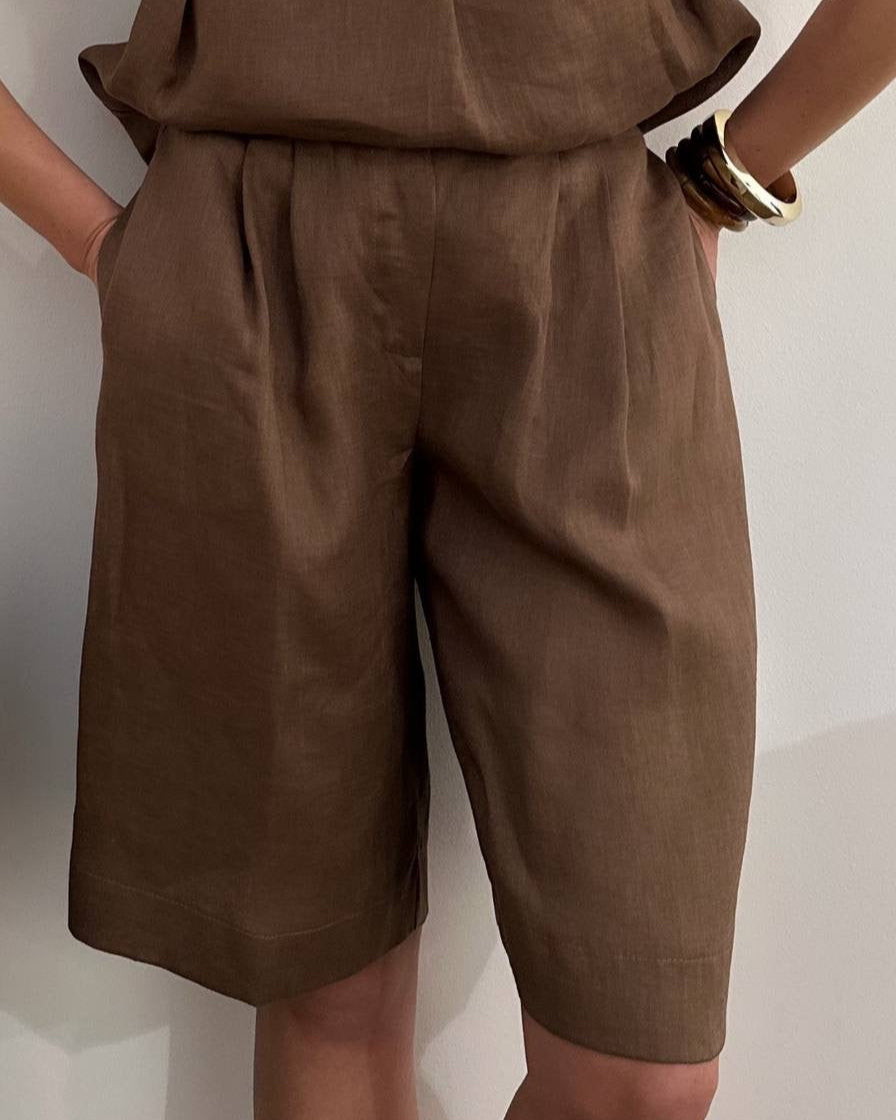 Brown shorts worn by a person against a plain background