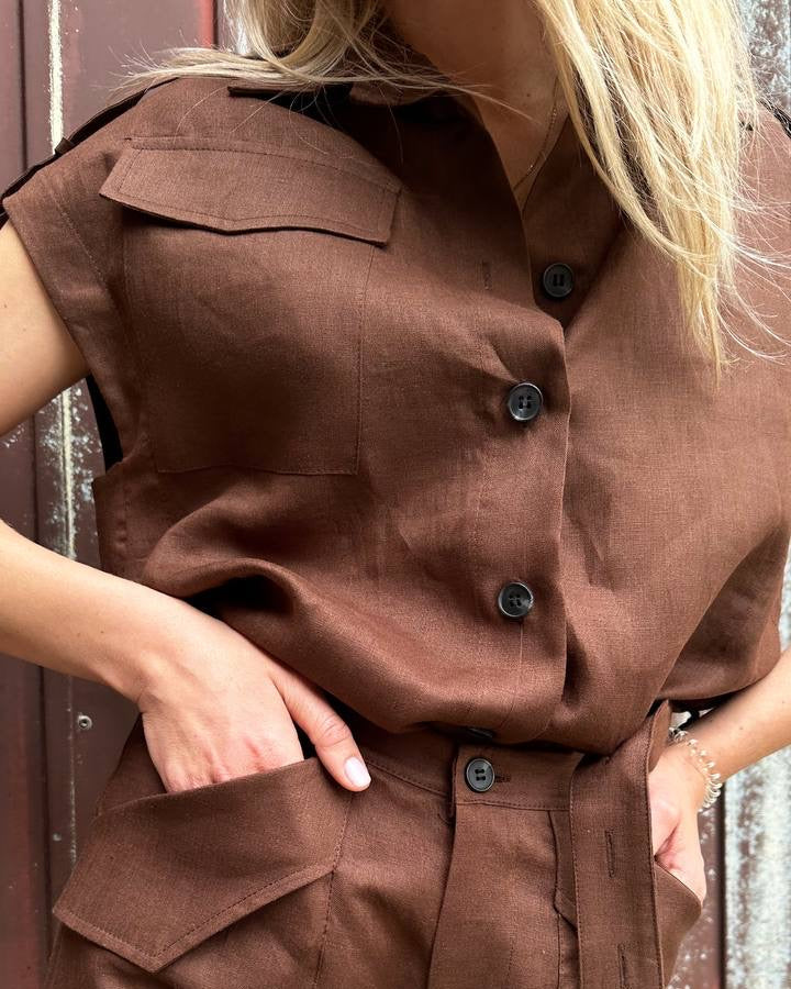 Brown sleeveless jacket with button details worn by a person.