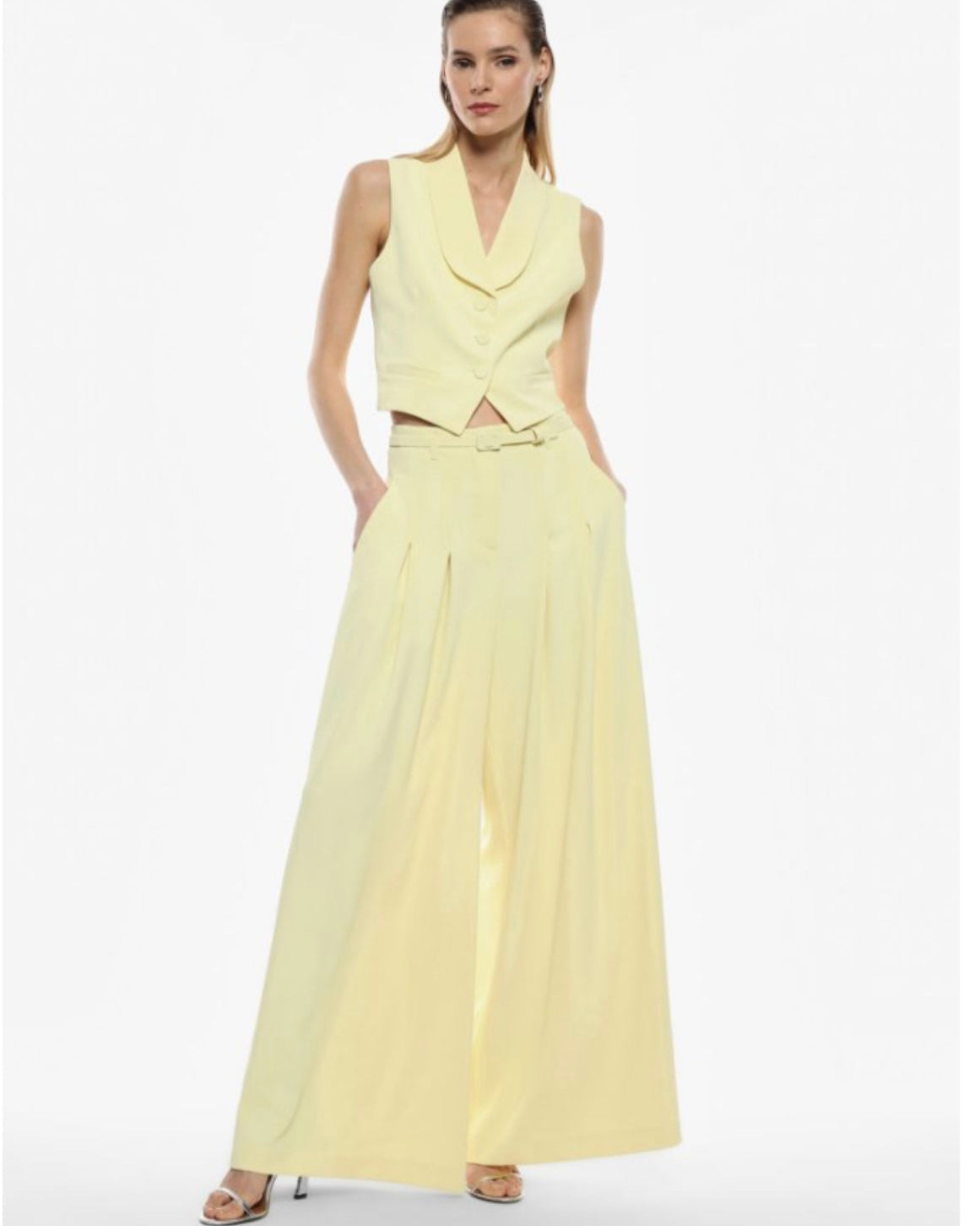 A model wearing a yellow sleeveless maxi dress with a V-neckline and wide-leg design.