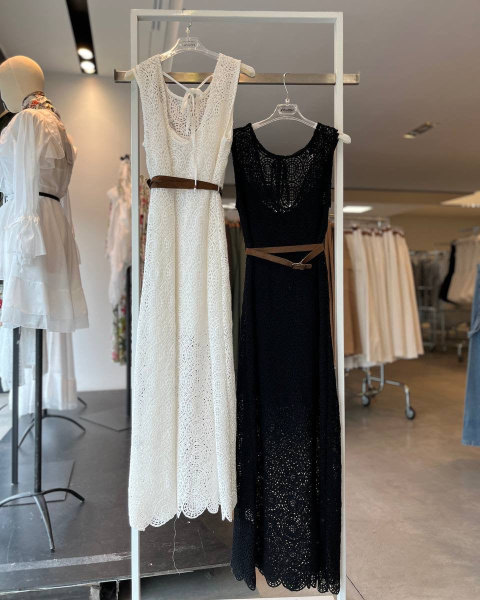 White and black lace dresses on hangers in a store setting