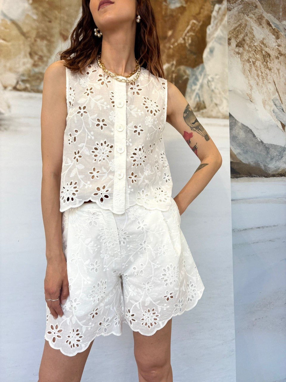 Woman wearing a white lace outfit with a neutral background