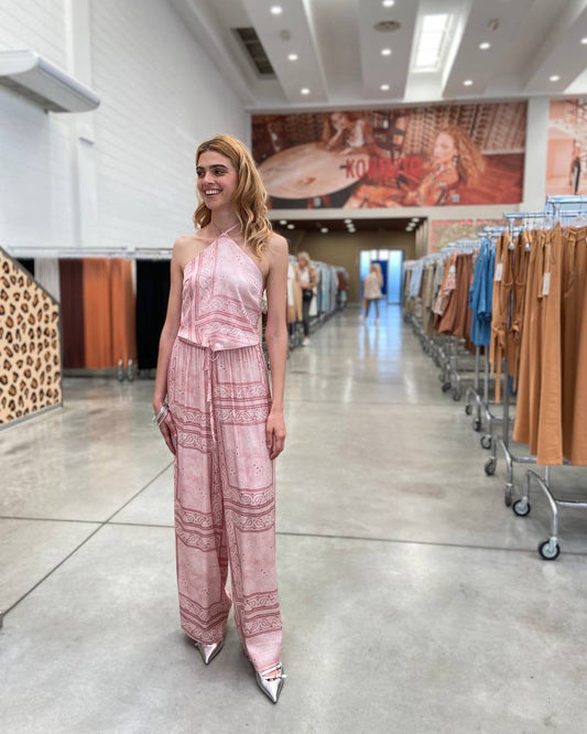 Woman in a pink outfit standing in a clothing store